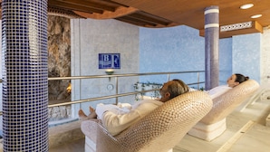 Un área de spa con dos sillones reclinables, una pared de piedra y un pilar con azulejos azules.