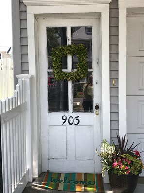 Welcome to your home away from home, where a beautiful wreath and potted flowers greet you at the door.