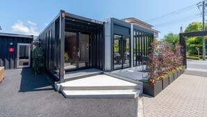A modern building with a glass entrance and a sign reading "CODO 231245". - HOTEL R9 Kujukuri (Ichinomiya)