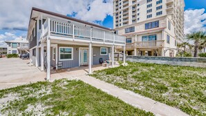 A two-story building with a covered patio and a small garden area. - Spacious Beachfront Condo NEWLY REMODELED (Jacksonville Beach)