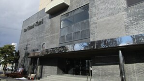 Een modern gebouw met een opvallend bord waarop “The Grand Hotel” staat.