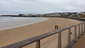 A beach with a wooden walkway and a stone wall. - Amazing Sea views.  Central location. Overlooking Portstewart Old Course. (Portstewart)