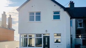 A two-story house with a front door, two windows on the ground floor, and a chimney. - Amazing Sea views.  Central location. Overlooking Portstewart Old Course. (Portstewart)