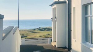 A narrow pathway leading to a building with a view of the sea. - Amazing Sea views.  Central location. Overlooking Portstewart Old Course. (Portstewart)