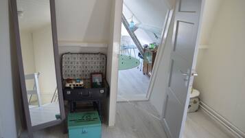 Cozy retreat with a large mirror, seating area, and compact storage unit.