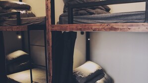 A bunk bed room with wooden frames and a sloped ceiling. - See U Hostel Osaka (Osaka)