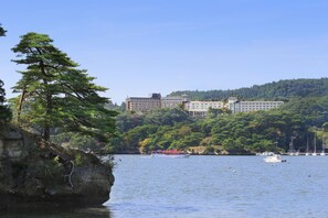 Un hôtel situé sur la côte, composé de plusieurs bâtiments, avec un rivage rocheux et une vue dégagée sur la mer.