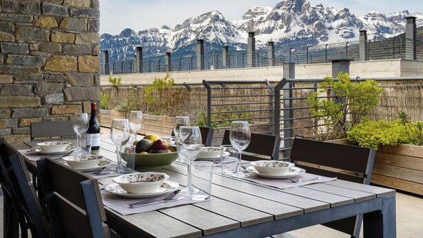 A table set for dining with a mountain view in the background. - Nice Stay B Paz: 2 terraces with incredible views. Wifi, BBQ, swimming pool, paddle. (Panticosa)