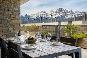 A table set for dining with a mountain view in the background. - Nice Stay B Paz: 2 terraces with incredible views. Wifi, BBQ, swimming pool, paddle. (Panticosa)
