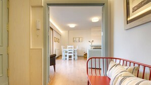 A modern living room with a red bench, a white sofa, and a dining area with white chairs and a table. - Nice Stay B Paz: 2 terraces with incredible views. Wifi, BBQ, swimming pool, paddle. (Panticosa)