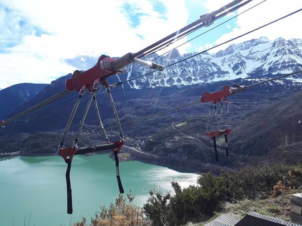 A cable car system with a mountainous backdrop and a lake.