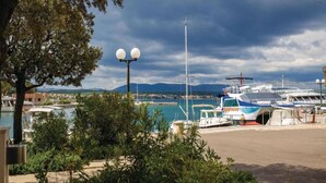 A marina with boats docked, a clear sky, and a view of distant mountains.