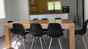 Une cuisine moderne avec une table en bois et des chaises noires, une fenêtre et un évier.