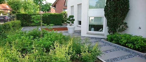 Et moderne hus med en velplejet have, en belagt sti og et stort vindue.