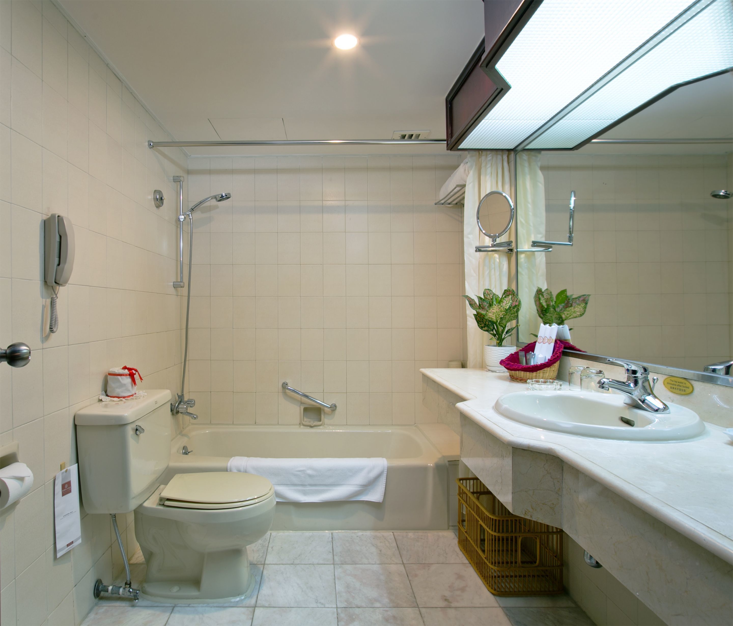 A bathroom with a toilet, bidet, bathtub, and a sink with a mirror.