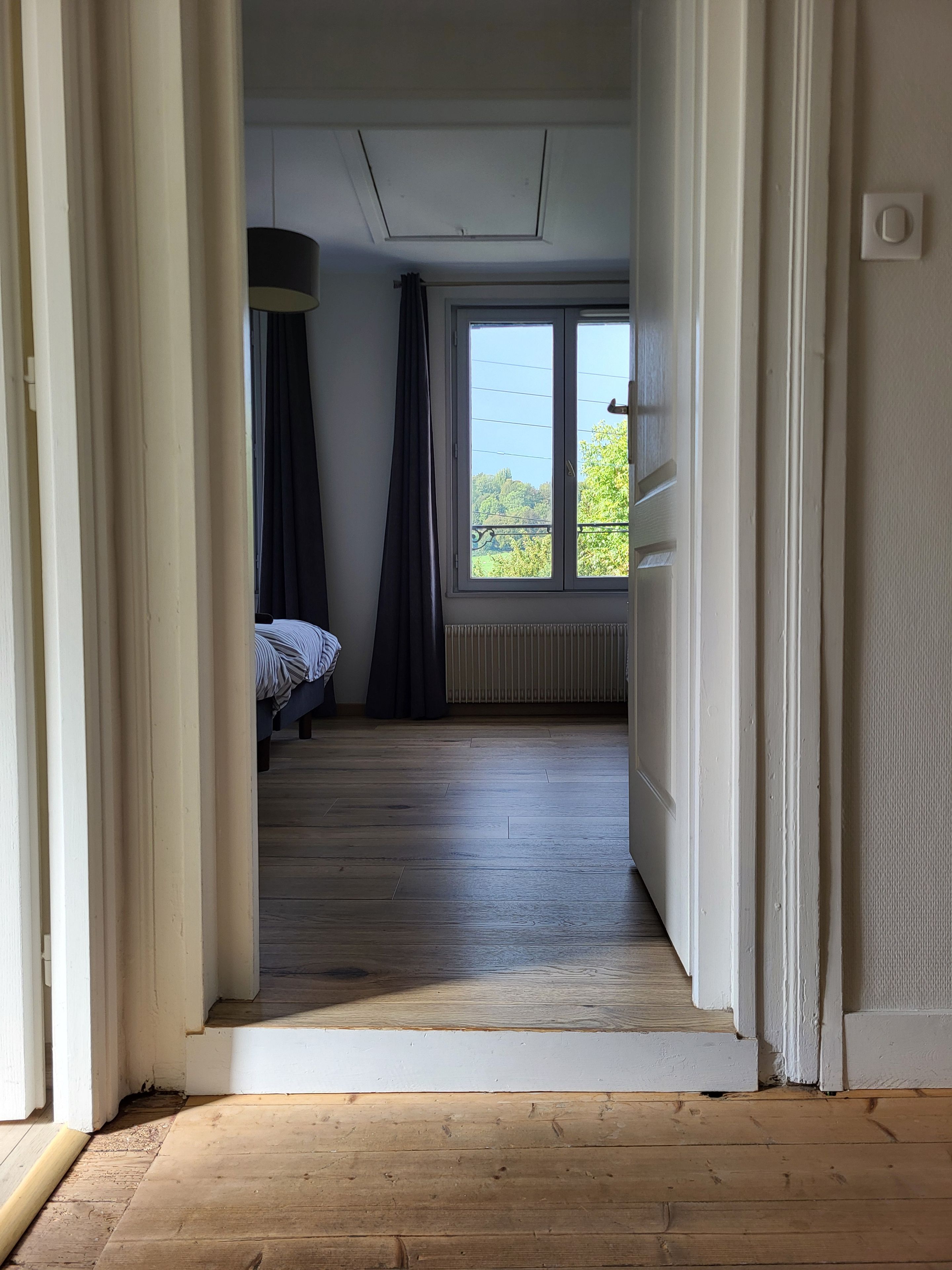 A room with a bed, a window, and a radiator.