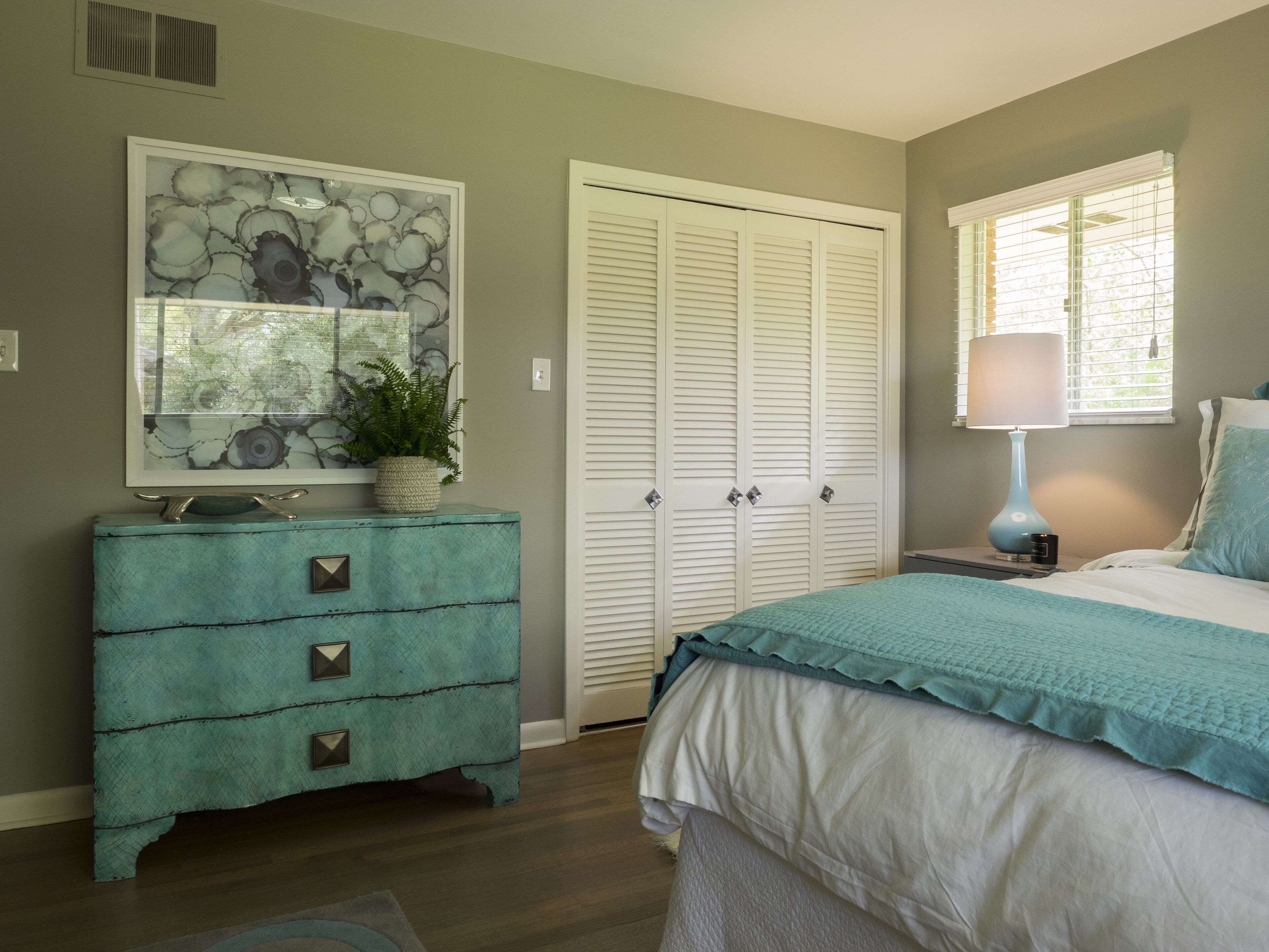 Un dormitorio con cama, cómoda y armario.