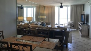 Una sala de estar moderna con un conjunto de sofás, una mesa de comedor y un televisor.