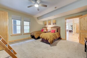 A bedroom with two beds, a ceiling fan, and a view of the adjacent living area. - BEST Location Park City: Walk In Out Ski. Town, Trails, Garage (PARK CITY)