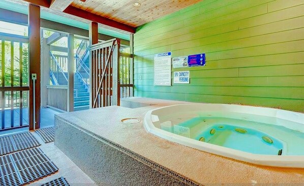 A spa area with a hot tub, a staircase, and a caution sign on the wall.