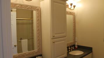 Un baño con lavamanos doble, un espejo con marco decorativo y un perchero para toallas.