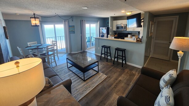 A modern living room with a dining area, kitchen, and balcony. - THE BEST!!  100% Newly Renovated  CLEAN! And The VIEWS!!   (Myrtle Beach)