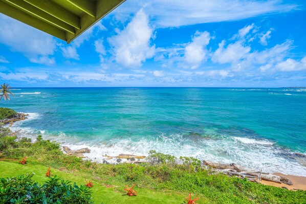 A coastal view with clear blue sky, turquoise sea, and rocky shoreline. - "Picture Perfect" Oceanfront on the Top Floor at Wailua Bay View! (Kapaa)
