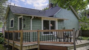 Ett litet hus i ett våningsplan med en veranda och en inglasad uteplats.