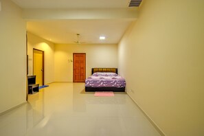 Une chambre à coucher avec un lit, un ventilateur de plafond et une porte.