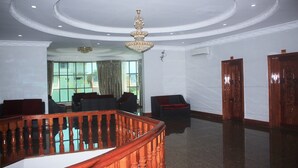 A spacious lobby with a polished floor, a grand wooden staircase, and a chandelier. - 7 Makara Hotel (Kampong Cham)