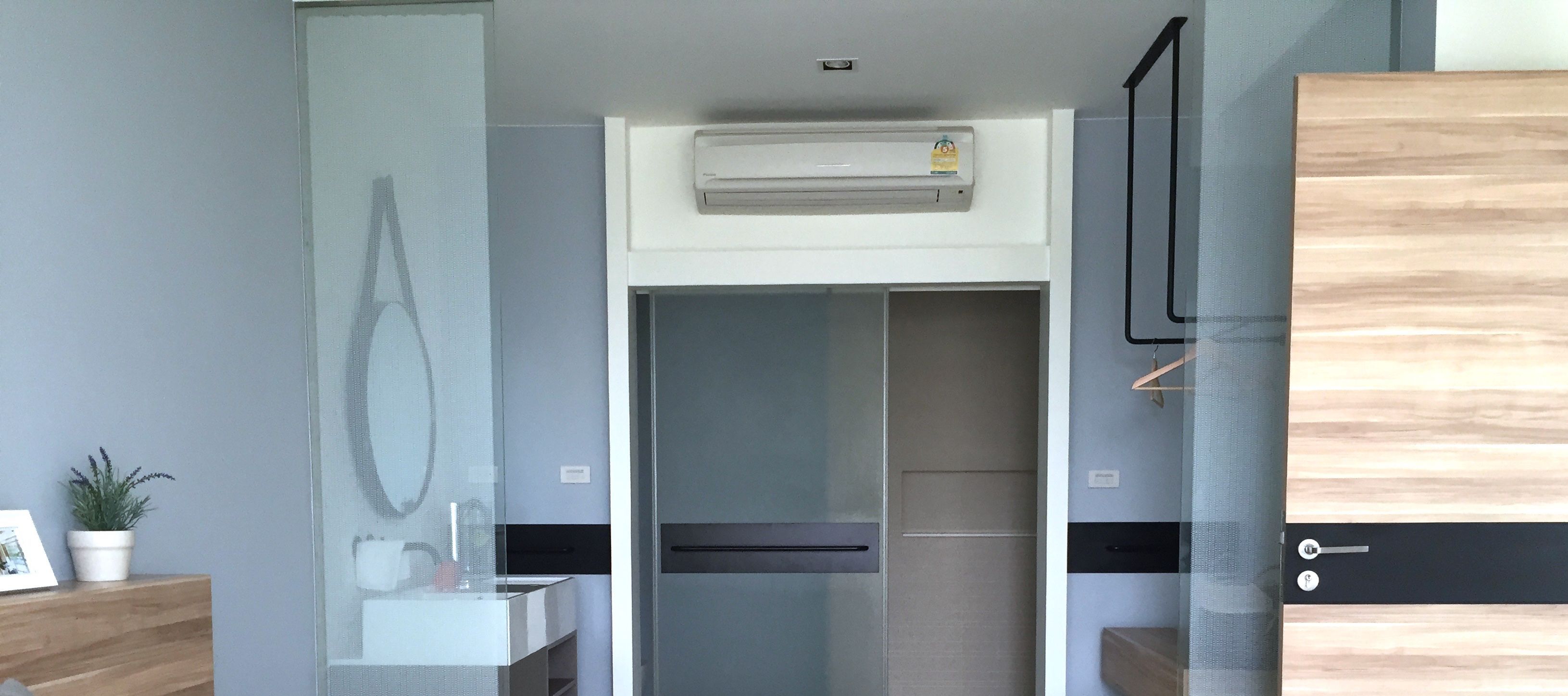 A modern bathroom with a glass partition, a built-in sink, and a towel rack.