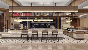 Un espace bar moderne doté d’un comptoir en marbre, de tabourets de bar et de diverses boissons et collations présentées sur des étagères.