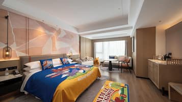 Una habitación de hotel con una cama grande, un escritorio, una silla, una mesita y una ventana.