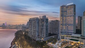Un hôtel de grande hauteur au design moderne, avec de nombreux étages et un nom bien visible sur le sommet.