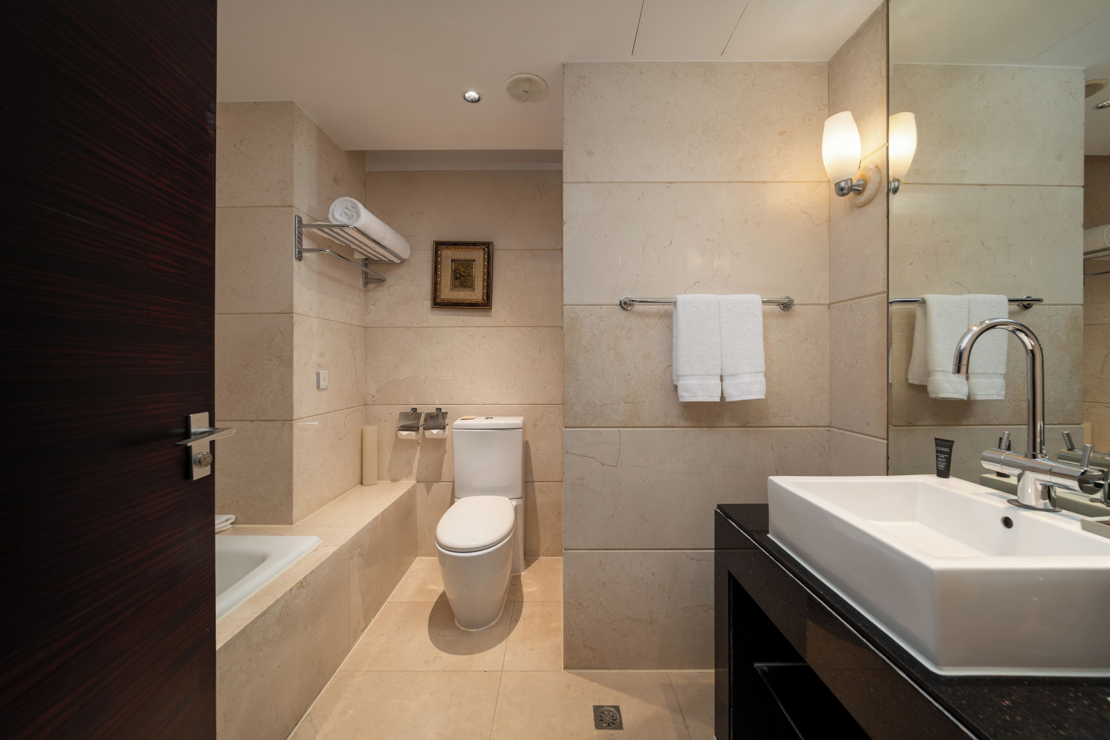 A modern bathroom with a bathtub, toilet, and sink.