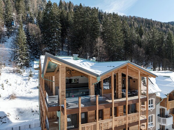 A wooden chalet with a glass balcony, surrounded by snow-covered trees and a clear sky. - Cerana Relax Hotel (Tre Ville)