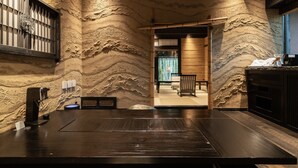 Un interior moderno con una pared de piedra, un mostrador de recepción de madera y una zona de estar con vistas.