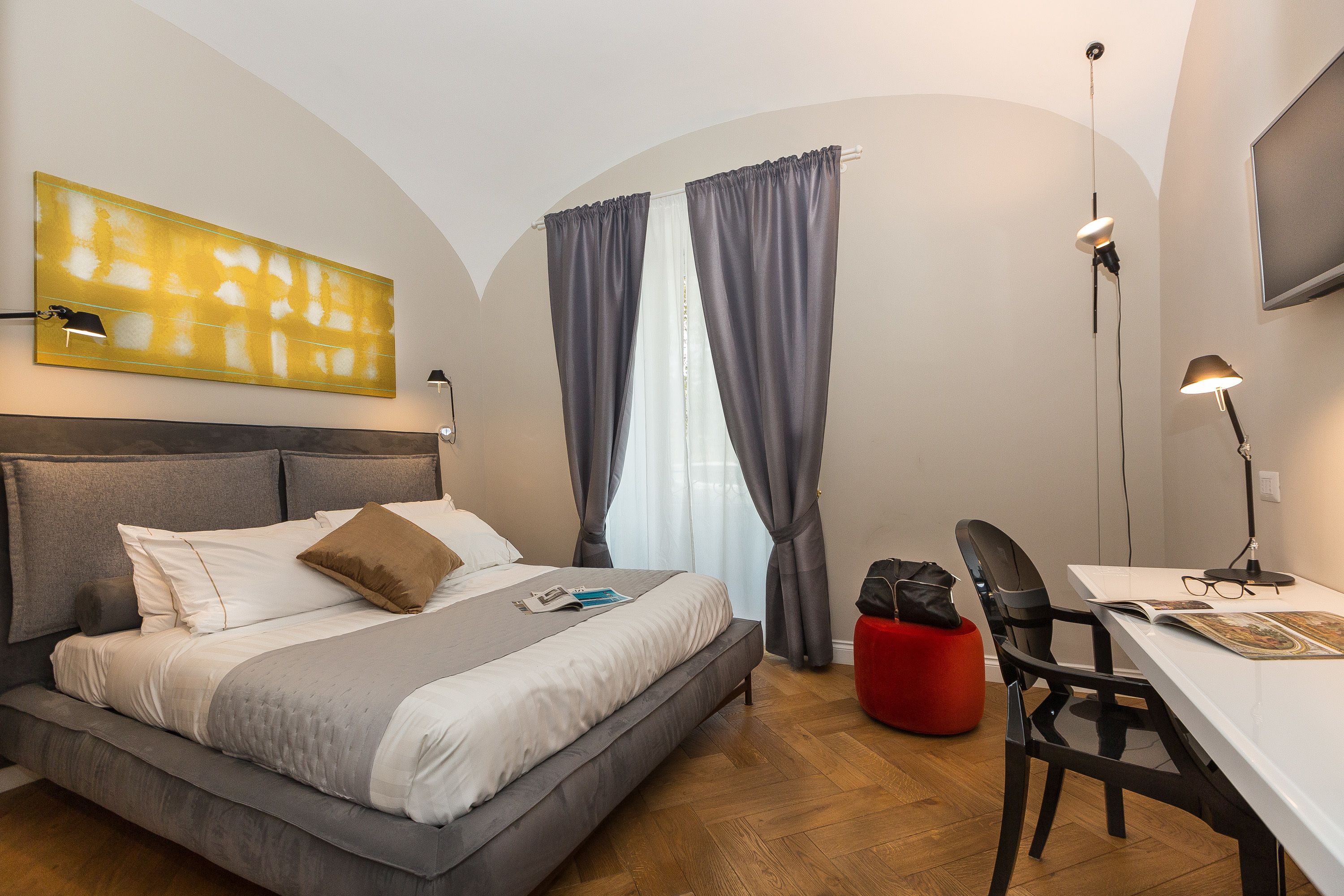 Moderni hotellihuone, jossa on suuri sänky, työpöytä ja tuoli.