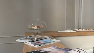 A modern kitchen with a wooden countertop, a glass display case, and hanging pendant lights.