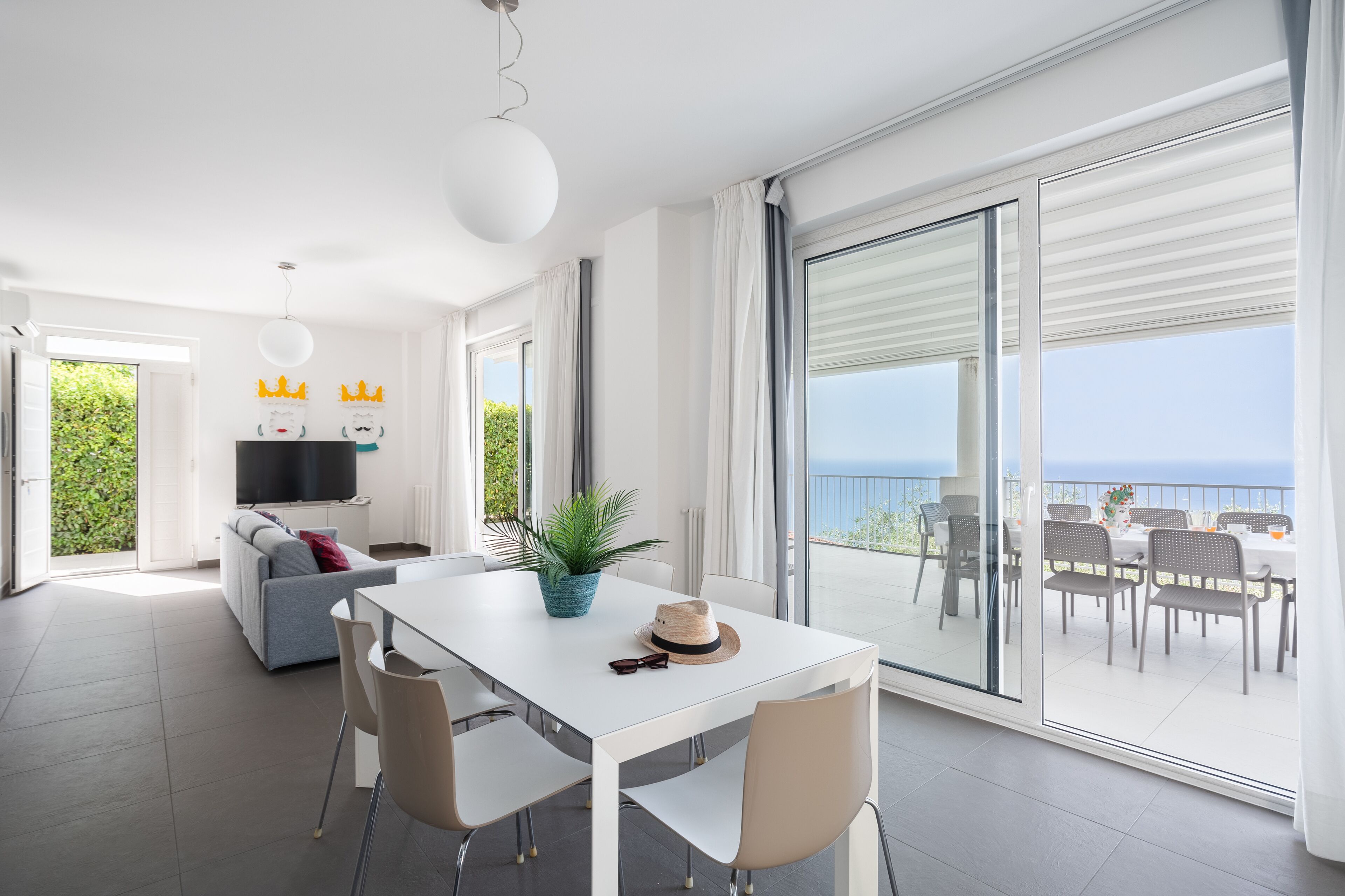 Un espace de vie moderne comprenant un coin repas, un canapé et un balcon avec vue.