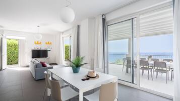 Un espace de vie moderne comprenant un coin repas, un canapé et un balcon avec vue.