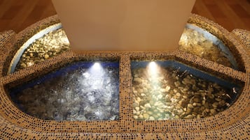 A decorative floor with a central pillar and three sections containing pebbles and water.