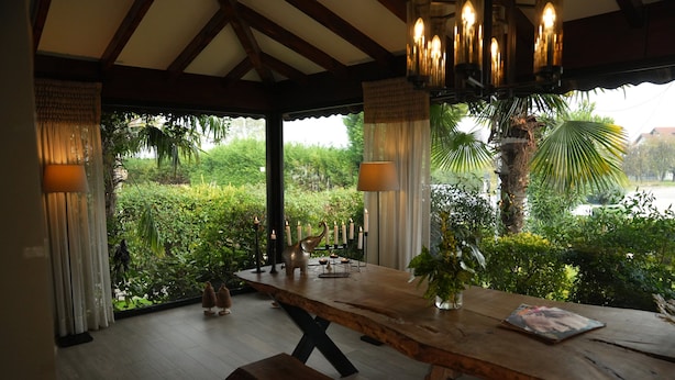 A wooden dining table with a bench, candles, and a decorative elephant figurine. - Cevizdibi Otel (Kartepe)