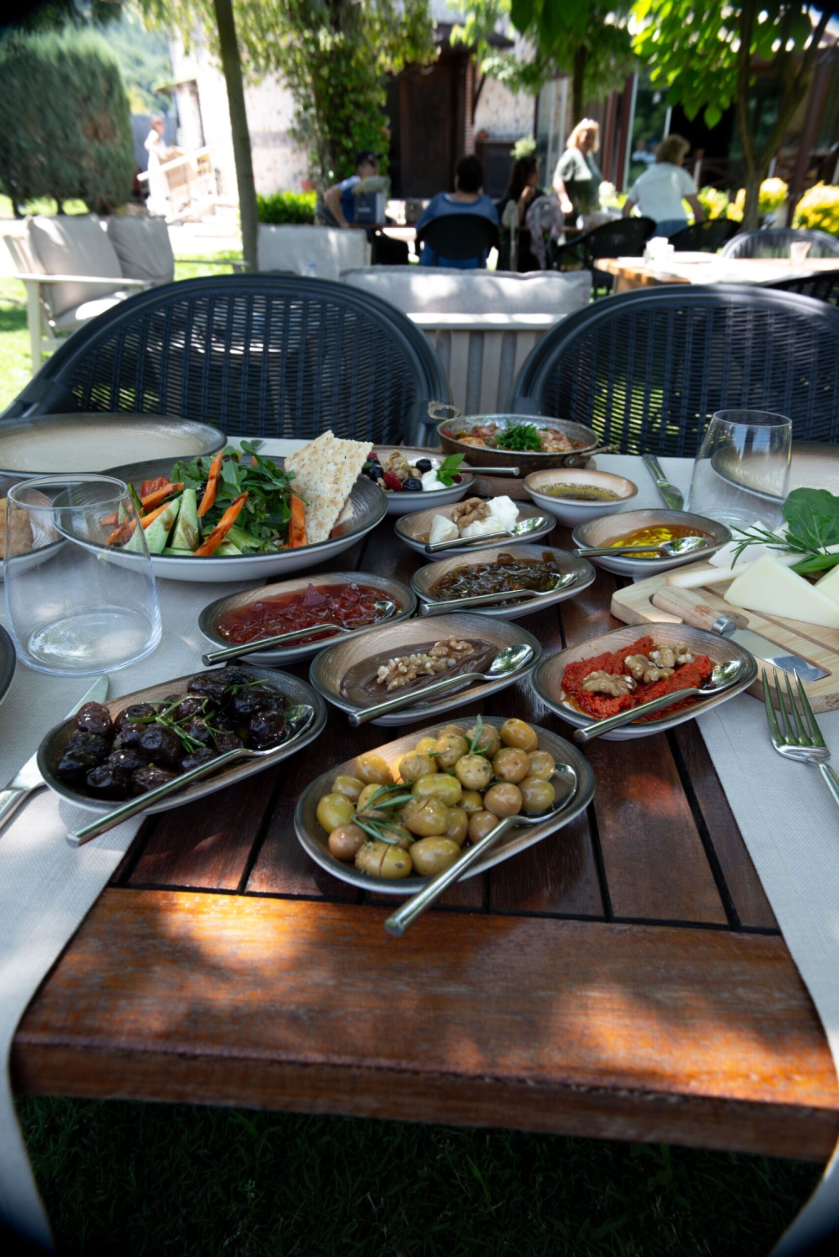An outdoor dining table with various dishes and utensils.