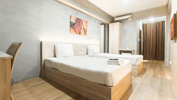 Quarto de hotel moderno com uma cama grande, uma escrivaninha e uma pequena mesa.