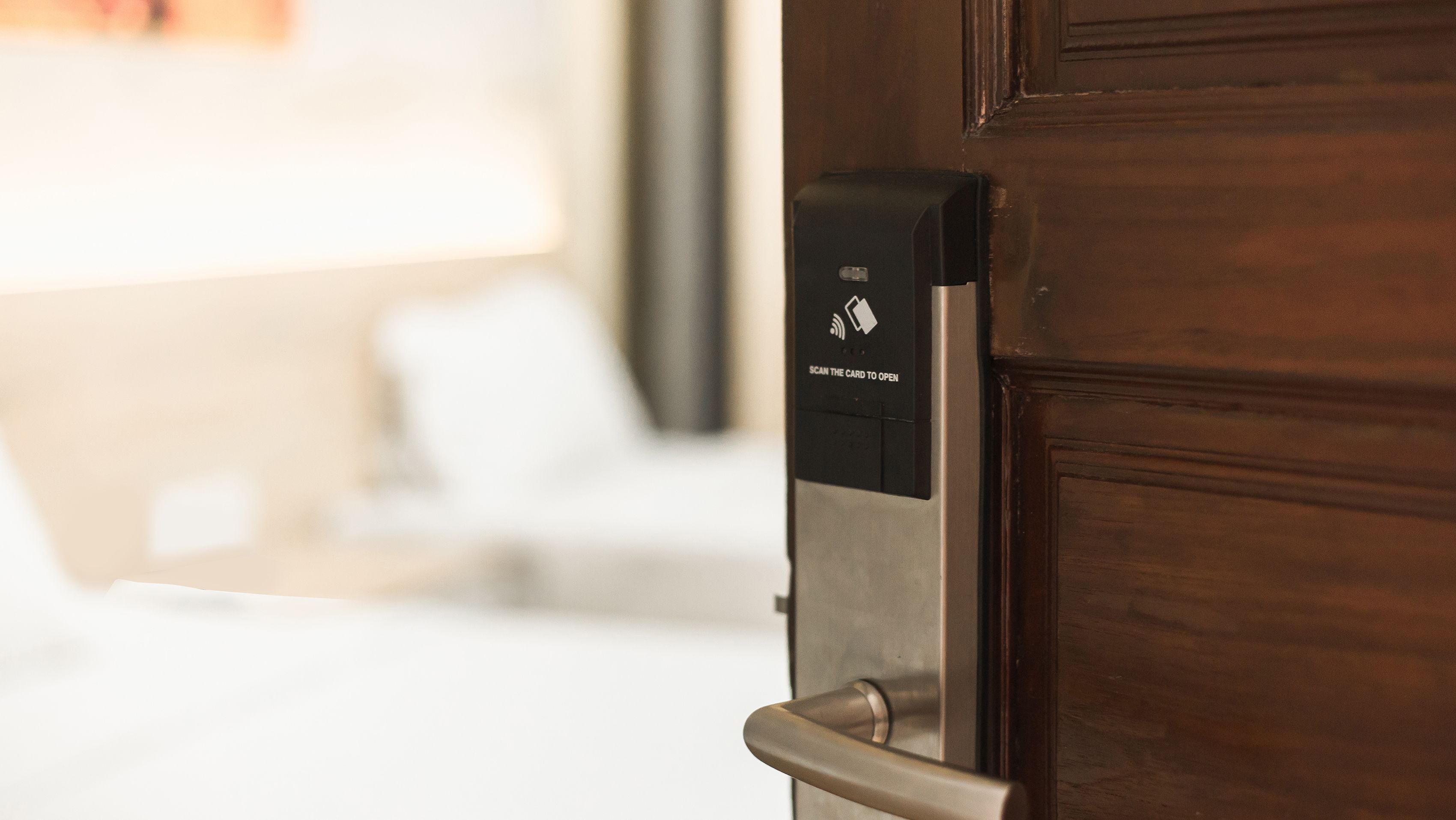 Puerta de una habitación de hotel con lector de tarjetas para acceso.