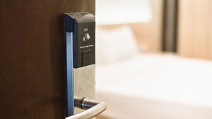 Porta de quarto de hotel com leitor de cartão para acesso.