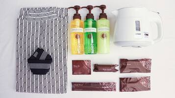 A neatly arranged set of toiletries including body shampoo, hair shampoo, hair conditioner, a toothbrush, a hair brush, a body sponge, and a hair brush.