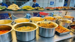 Un bufé con diversos platos, incluyendo arroz, curry y ensaladas.