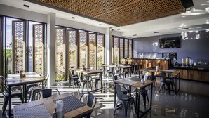 A modern restaurant with high ceilings, wooden lattice panels, and large windows offering views of the city. - Chaweng Villawee (Koh Samui)